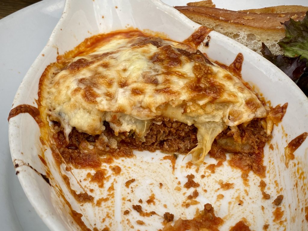 Cross-section of a moussaka, showing the different layers of rage, potato, aubergine and béchamel.