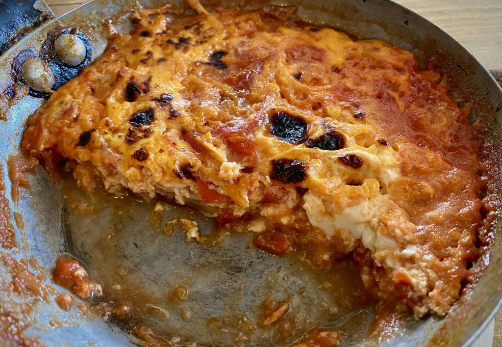 A cross-sectional shot of Menemen, showing the layers of egg, onions, tomatoes and peppers.