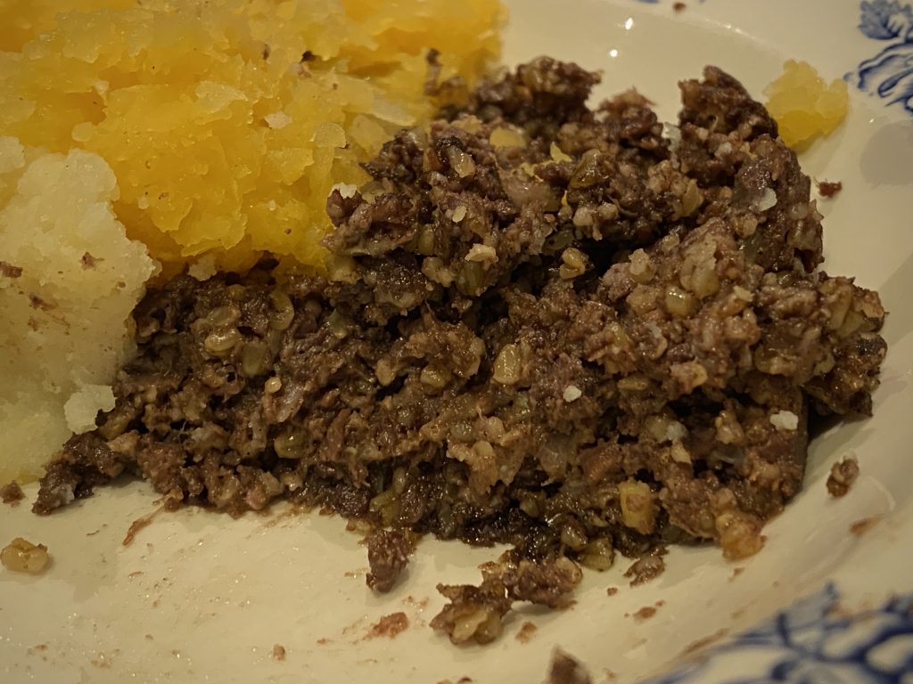 A close-up of haggis and neeps on a plate.
